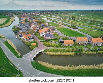 Aerial scenic view of typical Dutch village surrounded with polders and fields, North Holland, the Netherlands - Shutterstock ID 2227610241