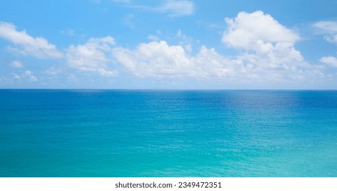 Aerial sea nature video filmed on a clear day, beautiful blue sea, horizon as far as the eye can see, blue sky, beautiful white clouds, straight plane horizon - Powered by Shutterstock