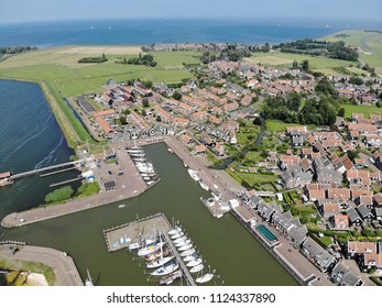 Aerial shoot from above with a small fishermens village and a Leisure harbour at a Dutch coastal town in the Netherlands
