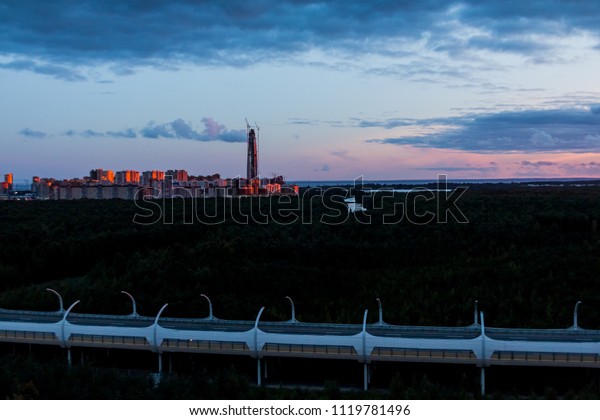 Aerial shooting of saint\
petersburg at night. City lights and traffic on the highway.\
Panoramic cityscape with illuminated buildings. Sunset time. white\
nights.Copy space