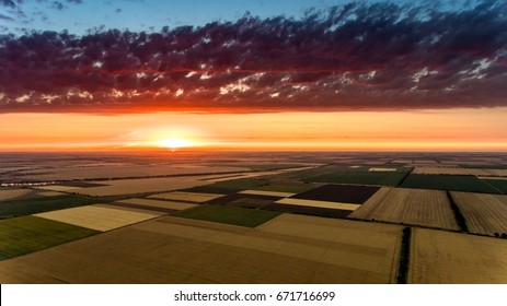 Aerial shot of an agricultural field at a chilling sunset in Ukraine in spring