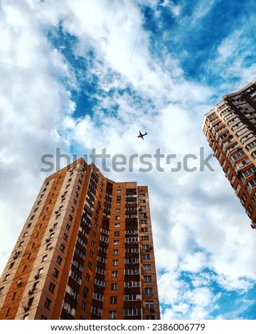 Aerial shot of an airplane flying over buildings in a metropolis with a blue sky in the background. Airline. Peaceful Kyiv Ukraine. vertical image