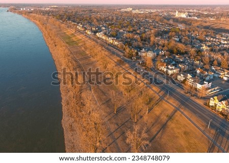 aerial shot along the shores of the Mississippi River at sunset with homes, apartments and office buildings on the banks at Greenbelt Park on Mud Island in Memphis Tennessee USA