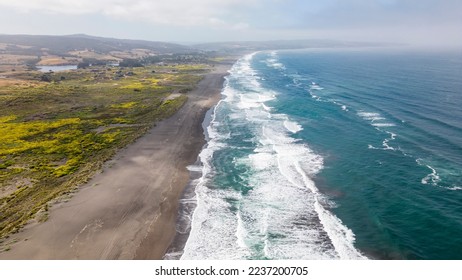 Aerial shot of a beach and the pacific ocean at Pichilemu, Chile 
