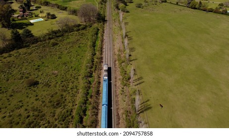 Aerial Shot Of Blue Train In Rural Area Of Buenos Aires During Summer. Top Down View