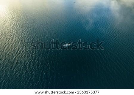An aerial shot of a boat in the endless sea