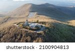 An aerial shot of a building located on a top of the Brasstown bald mountain  during the day