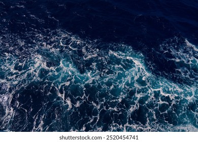 Aerial shot capturing the contrast between dark ocean waves and bright white seafoam, creating dynamic and dramatic seascape. Backgrounds or marine themes - Powered by Shutterstock