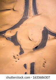 Aerial Shot Of A Car On A Roundabout Covered With Sand From The Desert
