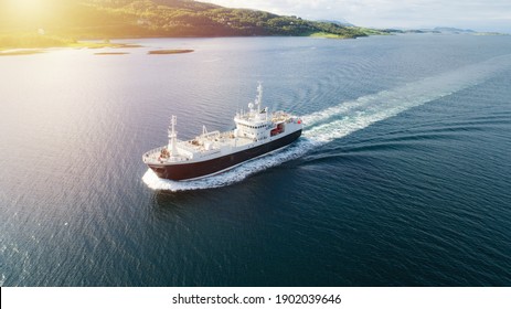 Aerial shot of a cargo ship in the sea. Mountains in the background, Norway, Lofoten. - Shutterstock ID 1902039646