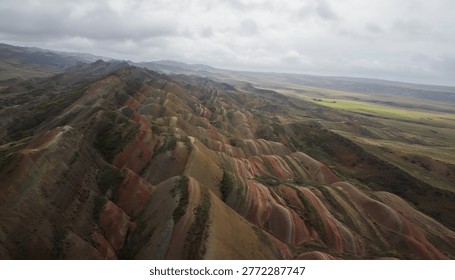 Aerial shot of the dramatic striped patterns of the rainbow mountains. Unique geological phenomenon in the David Gareja desert, Georgia.