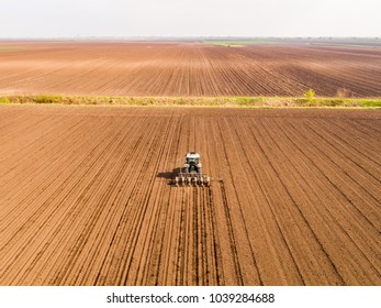 Aerial shot of a farmer seeding, sowing crops at field. Sowing is the process of planting seeds in the ground as part of the early spring time agricultural activities. - Shutterstock ID 1039284688