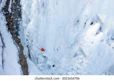 Aerial Shot Of An Ice Slope Bumps, Ridges, And Icicles By Which Climbing Up Man Using Traction Ice Tool Technique