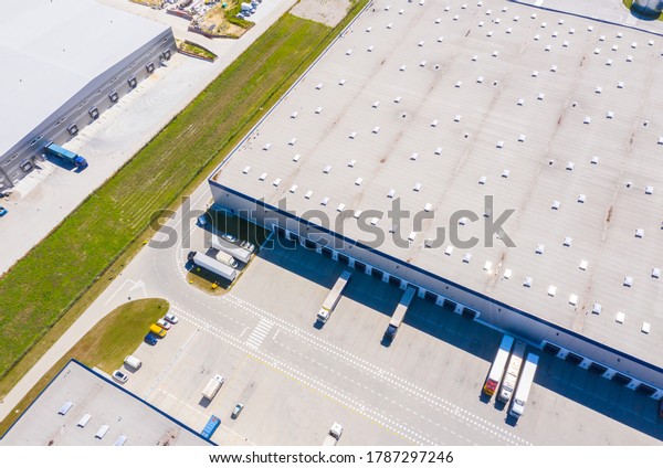 Aerial Shot of Industrial\
Warehouse Loading Dock where Many Truck with Semi Trailers Load\
Merchandise.
