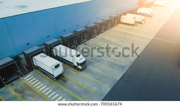 Aerial Shot of Industrial\
Warehouse Loading Dock where Many Truck with Semi Trailers Load\
Merchandise.
