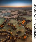 An aerial shot of a landscdape in autumn during the sunset