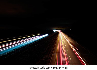 An aerial shot of a night road with colorful horizontal light lines - Shutterstock ID 1913847418