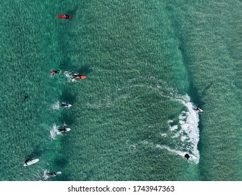 An Aerial Shot Of People Surfing In The Turquoise Sea