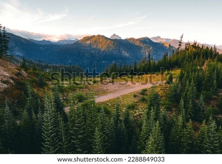 Aerial shot of shot of a pickup truck in front of Cascade mountains in Washington state. A perfect spot for camping off the grid.