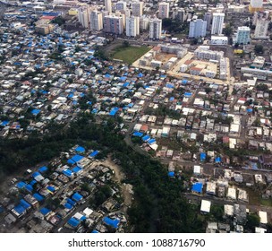 Aerial shot showing blue tarpaulin roofs of destroyed homes in San Juan, Puerto Rico six months after hurricane Irma & Maria. Jan 2018