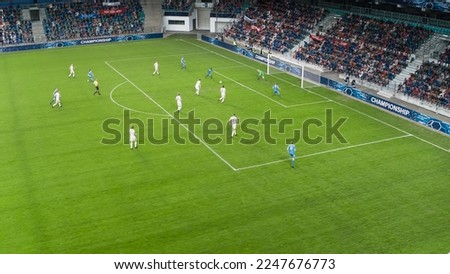 Aerial Shot: Soccer Football Championship: Black Forward From Blue Team Attacks, White Team Defends The Goals, Ready to Counterattack. Crowd of Fans Cheer. Sports TV Broadcast Concept. High Angle.