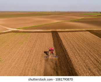 Aerial shot of a tractor cultivating field at spring - Shutterstock ID 1081790870