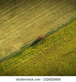 Aerial shot of tractor on the agricultural field sowing. Red tractors working on the agricultural field with sprayer. - Shutterstock ID 1326020600