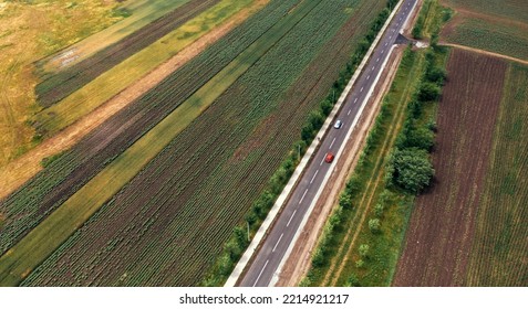 Aerial Shot Of Traffic On The Road Through Countryside, Drone Image Of Cars On Highway And Pedestrian Walking On The Sidewalk