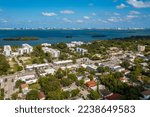 Aerial shot of Upper East Side residential neighborhood
in Miami, lush vegetation is seen, modern buildings, luxury houses, urban skyline, blue sky, street with cars