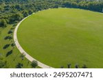 an aerial shot of the vast miles of lush green trees and grass with buildings nestled among the trees and powerful clouds at sunset at Etowah River Park in Canton Georgia USA	