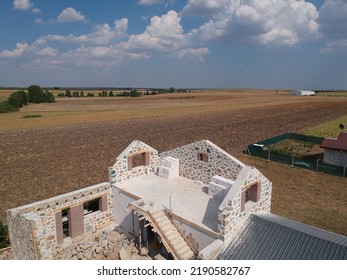 Aerial Shot Of White Stone House Under Construction And Field Seen Behind