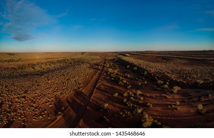 An Aerial Shot Of A Winter Sunset In Outback Australia, Red Dirt And Bush As Far As The Eye Can See.