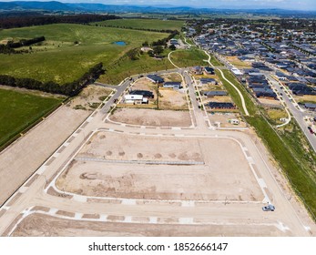 Aerial shots of a developing housing estate in the outer suburbs of Melbourne Australia, roads and gutters have been built, plots of land some already sold are almost ready for houses to be built. - Shutterstock ID 1852666147