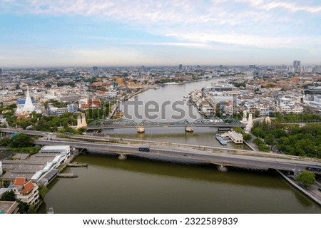 Aerial shots taken from a drone of Phra Pok Klao Bridge and Phra Phuttha Yot Fa Bridge. crossing the Chao Phraya River in the morning with temple and palace in background at Bangkok, Thailand
