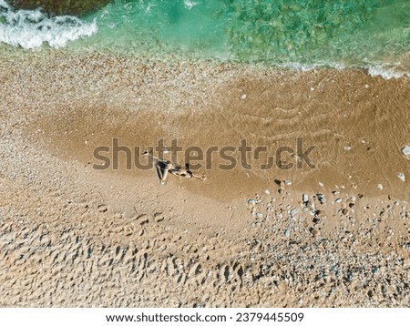 Aerial shots of a woman laying on the sand at the beach