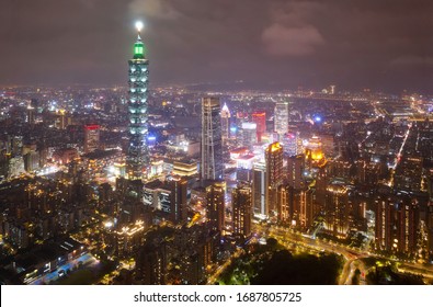 Aerial skyline of Downtown Taipei at night, the vibrant capital city of Taiwan, with 101 Tower standing out among modern skyscrapers in Xinyi Commercial District and city lights dazzling in the dark