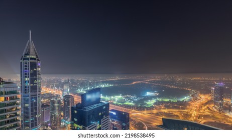 Aerial Skyline With Golf Club, Hotels And Residential Areas Far Away In Desert In Dubai During All Night Timelapse With Fog, UAE, Top View From Dubai Marina Skyscrapers. Lights Turning Off