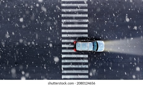 Aerial. Snow Or Rain Falls On The Road. Car Driving At Winter. Top View From Drone.