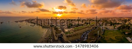 Aerial summer sunset view of Acco, Acre, Akko medieval old city with green roof Al Jazzar mosque and crusader palace, city walls, arab market,  knights hall, crusader tunnels,  in Israel