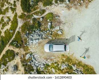 Aerial Summer Top Down View Of Car And Two Tourists Playing With Shadows In Videdalen Valley On Gamle Strynefjellsvegen Scenic Route In Norway