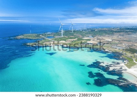 Aerial and summer view of blue sea and Gimnyeong Beach against wind generators at Gujwa-eup near Jeju-si, Jeju-do, South Korea
