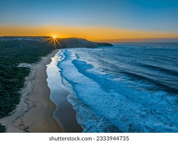 Aerial sunrise seascape with good size waves at Killcare Beach on the Central Coast, NSW, Australia.