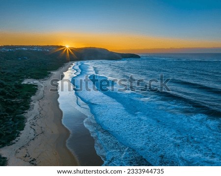 Aerial sunrise seascape with good size waves at Killcare Beach on the Central Coast, NSW, Australia.