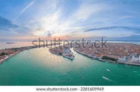 Aerial Sunset or Sunrise Shot of Central Venice city skyline, Italy. Panorama drone top view of famous tourist attraction from above. Basilica di Santa Maria della Salute, Grand Canal and lagoon. 