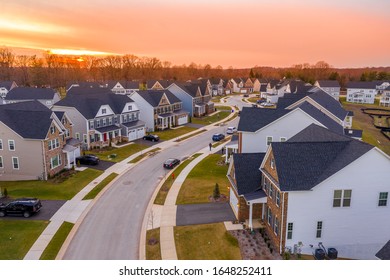 Aerial sunset view of curving contemporary American neighborhood street with newly constructed single family homes in the East Coast United States - Powered by Shutterstock
