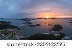 Aerial and sunset view of road and houses of a village on Sinsido and Seonyudo Island against sea and glow in the sky near Gunsan-si, South Korea
