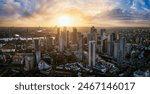 Aerial sunset view of the skyline of London with skyscrapers at Canary Wharf and the City in the background, England