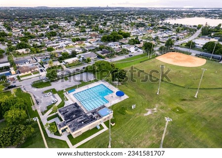 Aerial of a swimming pool and baseball field inside Norman and Jean Reach Park on Palm Springs North, Miami-Dade County, Florida, United States.