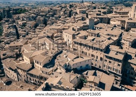 Aerial tapestry: Siena’s historic rooftops bask in sunlight (Italy)