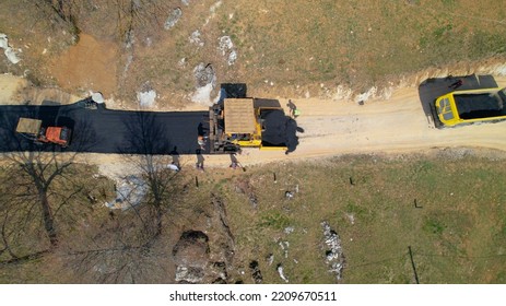 AERIAL TOP DOWN: Construction Workers Laying Asphalt And Freshly Paved Driveway. Builders Preparing Terrain For Finishing Paving The Roadway In Morning Light. Roadworkers Asphalt Paving Driveway.